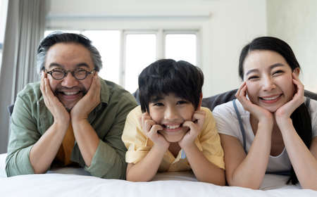 Portrait of happy Asian family spending time together on sofa in living room. family and home...