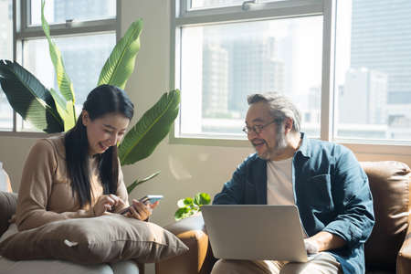 Asian Middle-aged Asian couple in living room at homeの写真素材