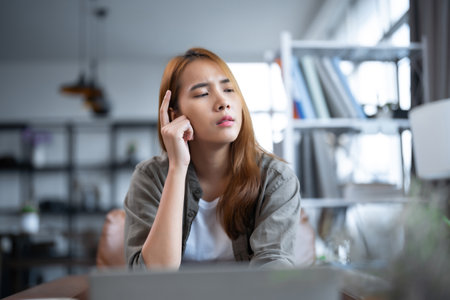 Serious thinking Young Asian woman working on laptop computerの写真素材