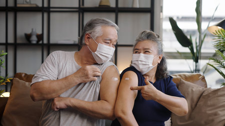 Asian mature couple show shoulder with aid after injection a being vaccinated.の写真素材