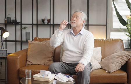 Asian elderly man self test for COVID-19 at home with Antigen test kit.の写真素材