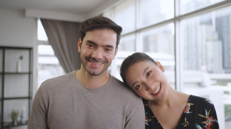 Portrait young couple looking at camera at homeの写真素材