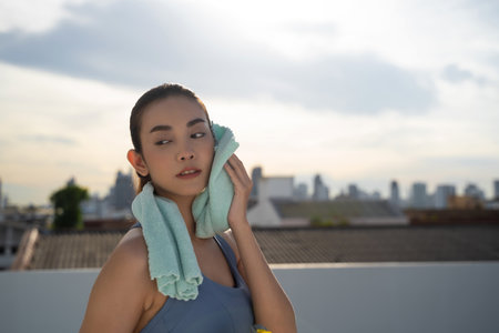 Young Asian woman resting after running exercise.outdoor exercise fitness conceptの写真素材