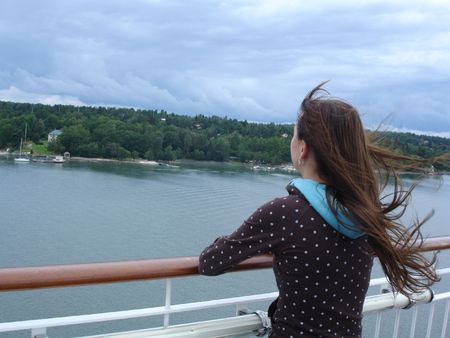 The girl looking at the ocean traveling by the shipの写真素材
