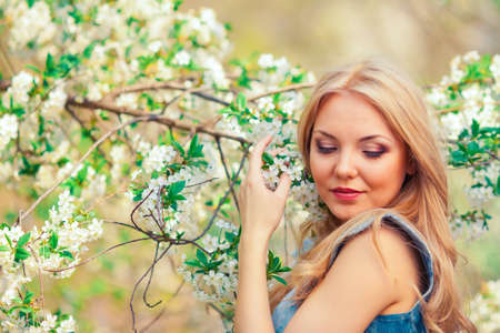 portrait of beautiful woman in blooming tree in spring