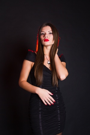 portrait of beautiful brunette woman in black dress on black backgroundの写真素材