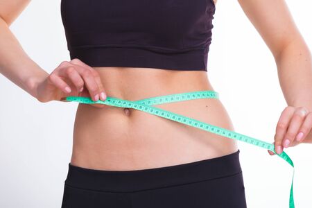 Mid section of sexy young woman with perfect body over white background