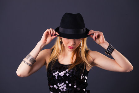 blond hair beautiful woman in black sequin dress on black backgroundの写真素材