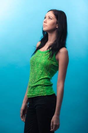 Beautiful casual young woman standing against blue backgroundの写真素材