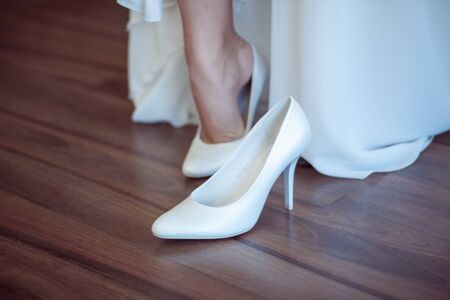 The bride dress her white wedding shoesの写真素材