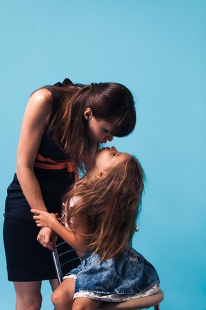Young mother with daughter on blue backgroundの写真素材