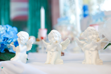 Three statues of angels on the tableの写真素材