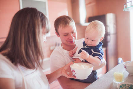 Happy family cooking homemade pie at kitchenの写真素材