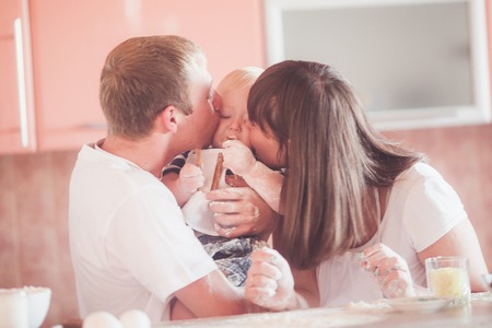 Portrait of happy family. Mother and father kissing childの写真素材