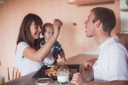 Happy family at kitchen with homemade pieの写真素材