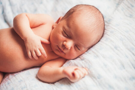 Sweet newborn baby sleeping on white blanket