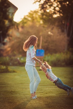 Mother and little daughter playing together in a parkの写真素材
