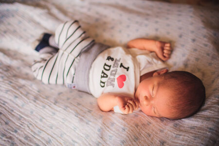newborn little baby boy sleeping on blanket