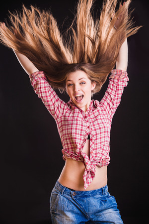 Horizontal portrait of beautiful young jumping woman in checkered shirtの写真素材