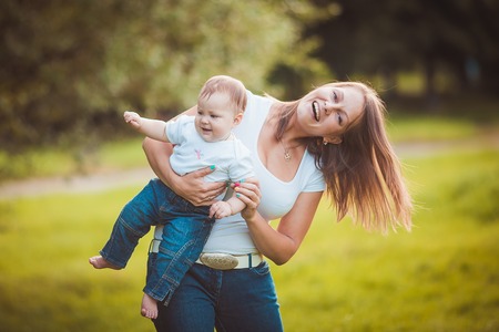 Happy mother with baby in summer green park