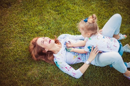 Mother and little daughter paint together outdoors