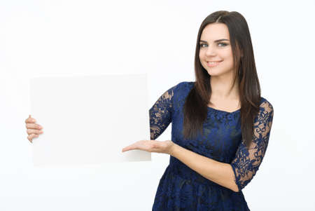 Advertising. Young smiling woman show blank card or paper on white background.の写真素材