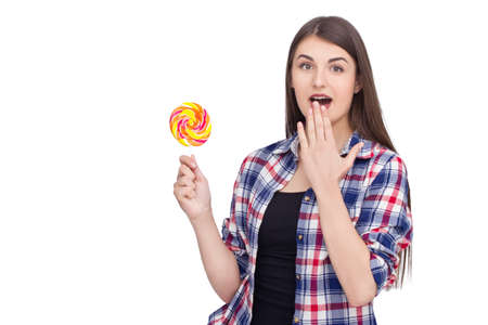 Young excited woman holding lolipop on isolated backgroundの写真素材