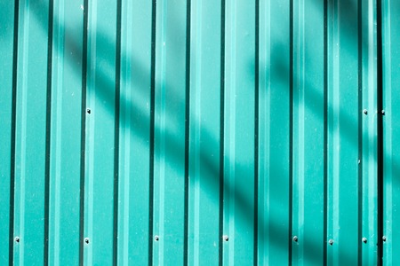 a peace of green striped panel metal fence.
