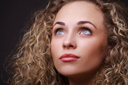 Closeup portrait of woman with curly hair. Thinking about. Sensual portraitの写真素材