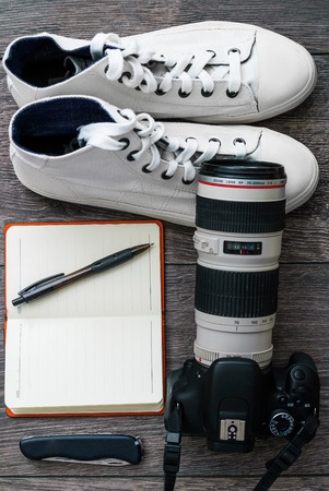 Outfit of traveler or student. Overhead of essentials for modern young person. Different objects on wooden background.の写真素材