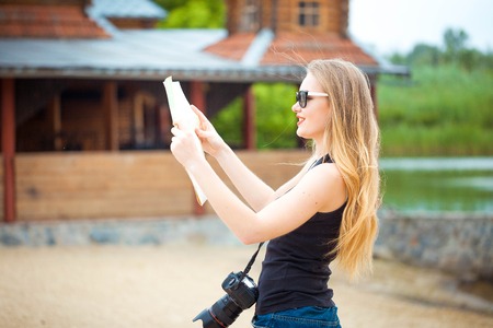 Young woman traveling in country by weekend. searching road on the map. looking place for photoの写真素材