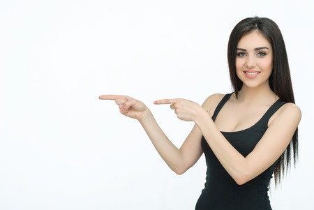 Advertising. Yound beautiful woman showing something. Girl pointing up on something. Woman pointing on copy spaceの写真素材
