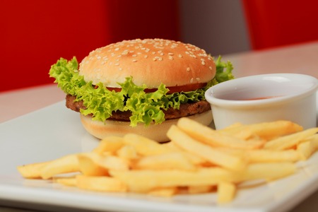 classic burger with French fries on the table in a cafe