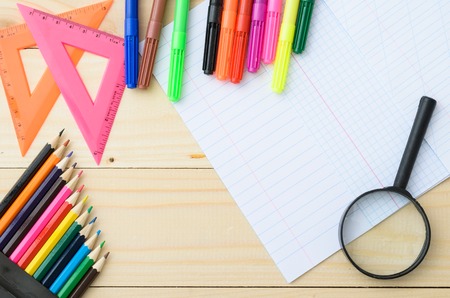 School stationery with pages from notebook copyspace on wooden boardの写真素材