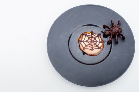 Belgian waffle decorated with chocolate spider web on white backgroundの写真素材