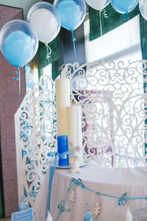 Blue and white candles tied with a ribbon on the tableの写真素材