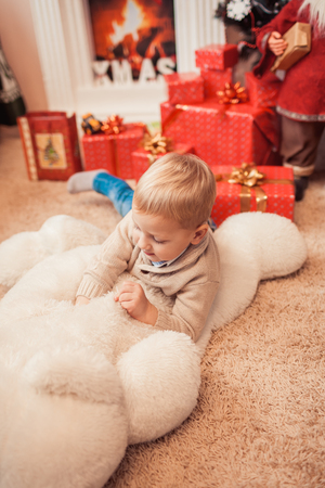 Happy family at christmas time. Child playing with big white bear in living room with xmas decorationsの写真素材