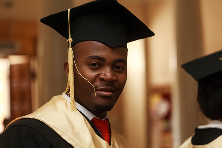 Graduate students wearing graduation hat and gown, outdoorsの写真素材