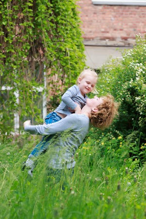 Mother and little daughter playing together in a parkの写真素材