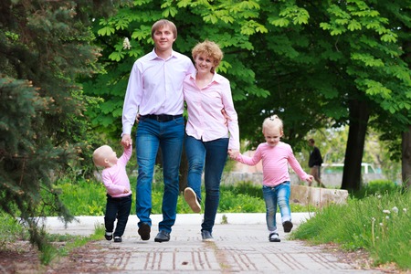 Happy young family spending time together outside in green parkの写真素材