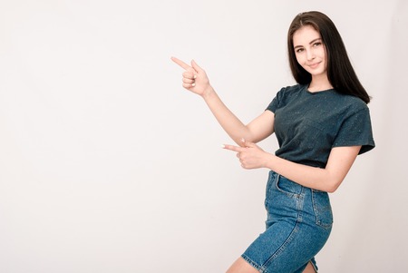 Smiling pretty girl pointing on blank copy copy space for product or textの写真素材