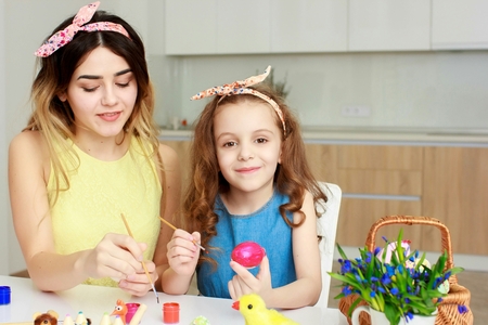 Mother and her daughter painting Easter eggs, preparing for Easter.の写真素材