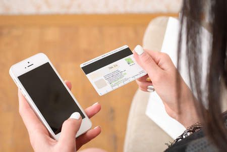 Close-up Of Businesswoman Paying With Credit Card On Mobile Phone.の写真素材