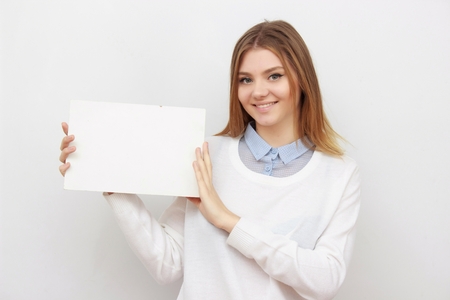Young smiling woman show blank card or paperの写真素材