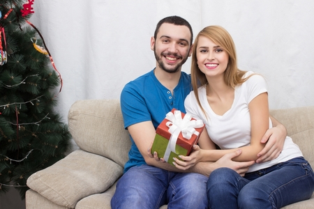 Guy gives christmas gift to girlfriendの写真素材