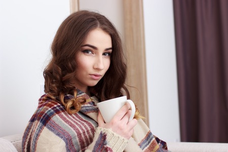 woman sitting on her white sofaの写真素材