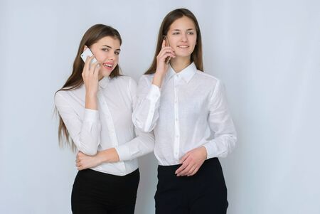 Isolated portrait of two young woman phone call. Isolated beautiful girls.の写真素材