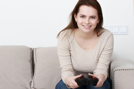 Pretty teenager playing videogame at homeの写真素材