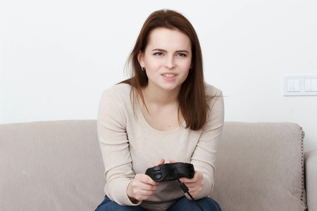 Pretty teenager playing videogame at home
