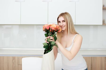 young and beautiful woman with vase of flowersの写真素材